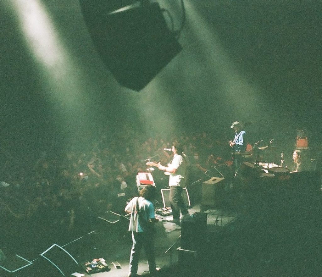 Band on stage with a view of the audience in dark venue