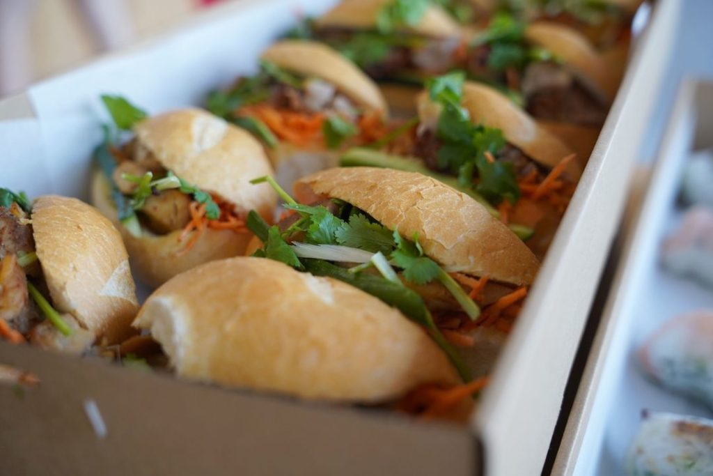 Rows of banh mi sandwiches packed in an open box