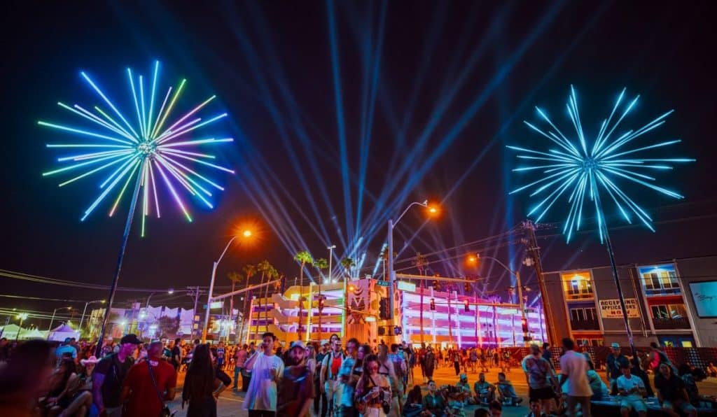 Electric flowers which take shape of fireworks above crowds and buildings