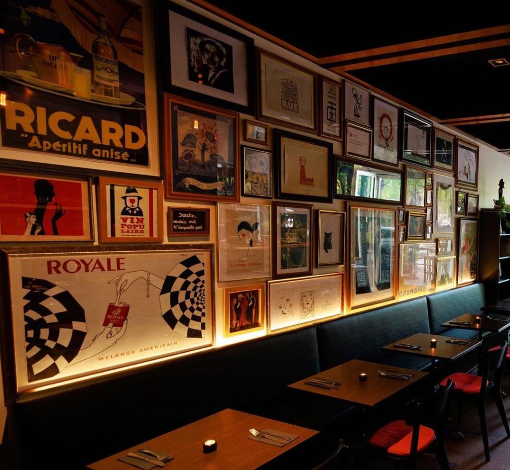Inside of Le Pas Sage walls adorned with vintage posters and contemporary art