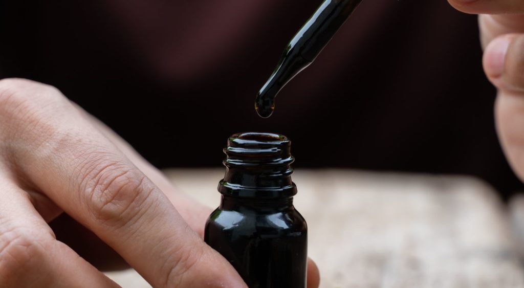 Open bottle of medicinal oil in a liquid droper