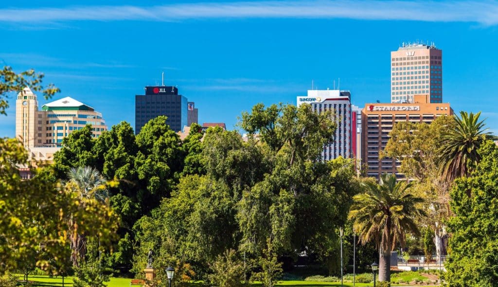 Adelaide city skyline peeping out behind trees and greenery